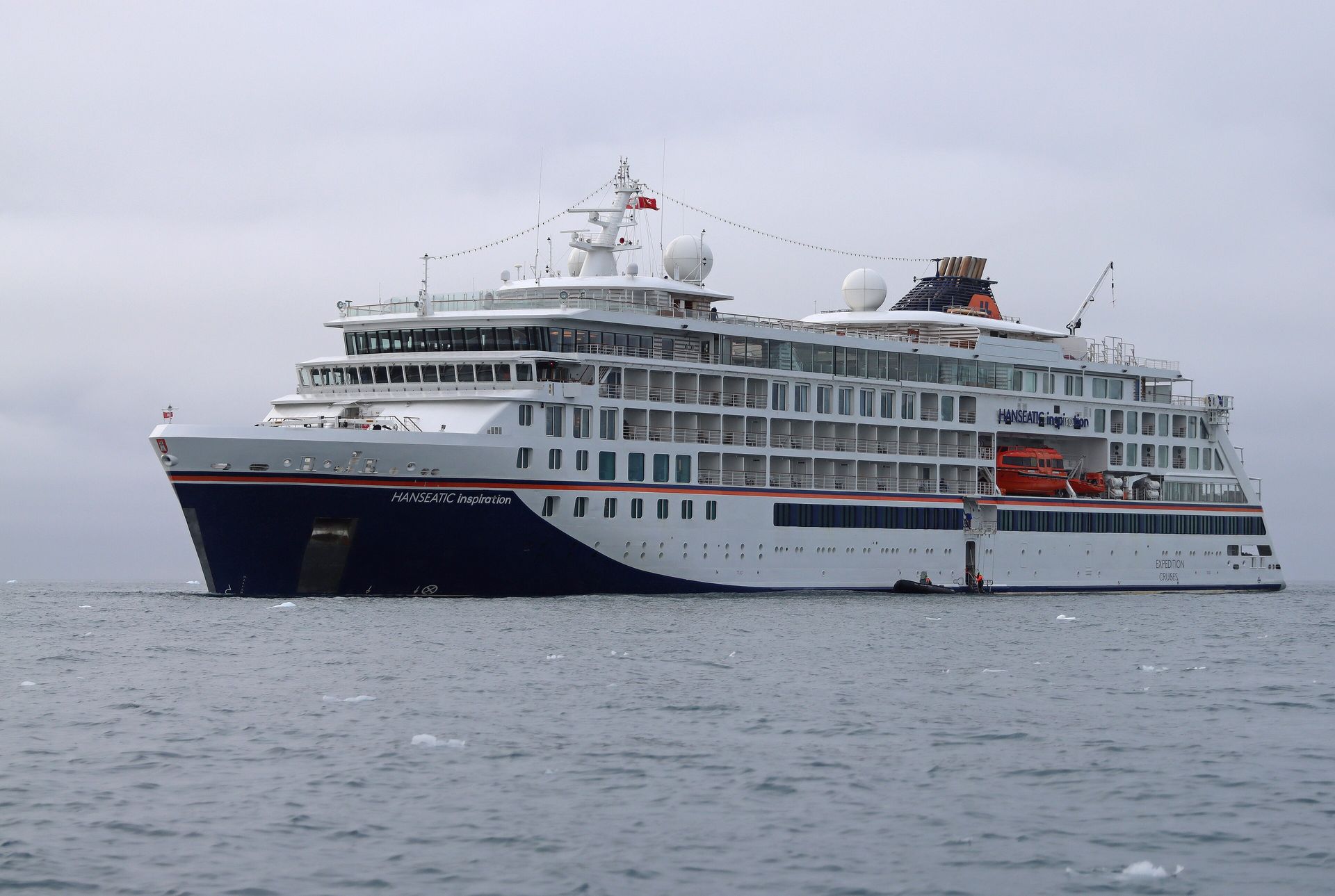 HANSEATIC inspiration, white with a navy bow, at anchor among small ice floes in Disko Bay, Greenland