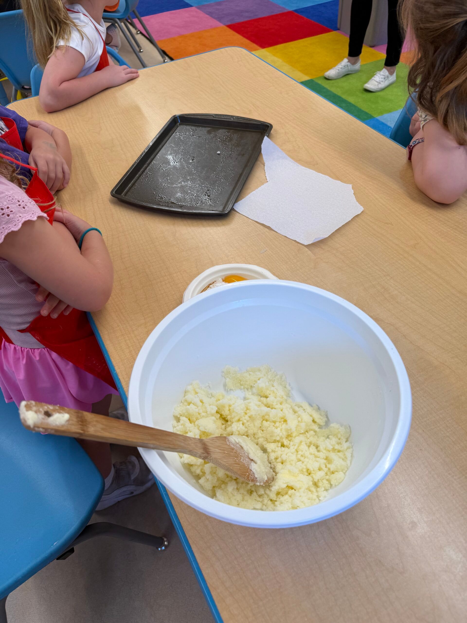 A preschooler mixing dough in a big bowl