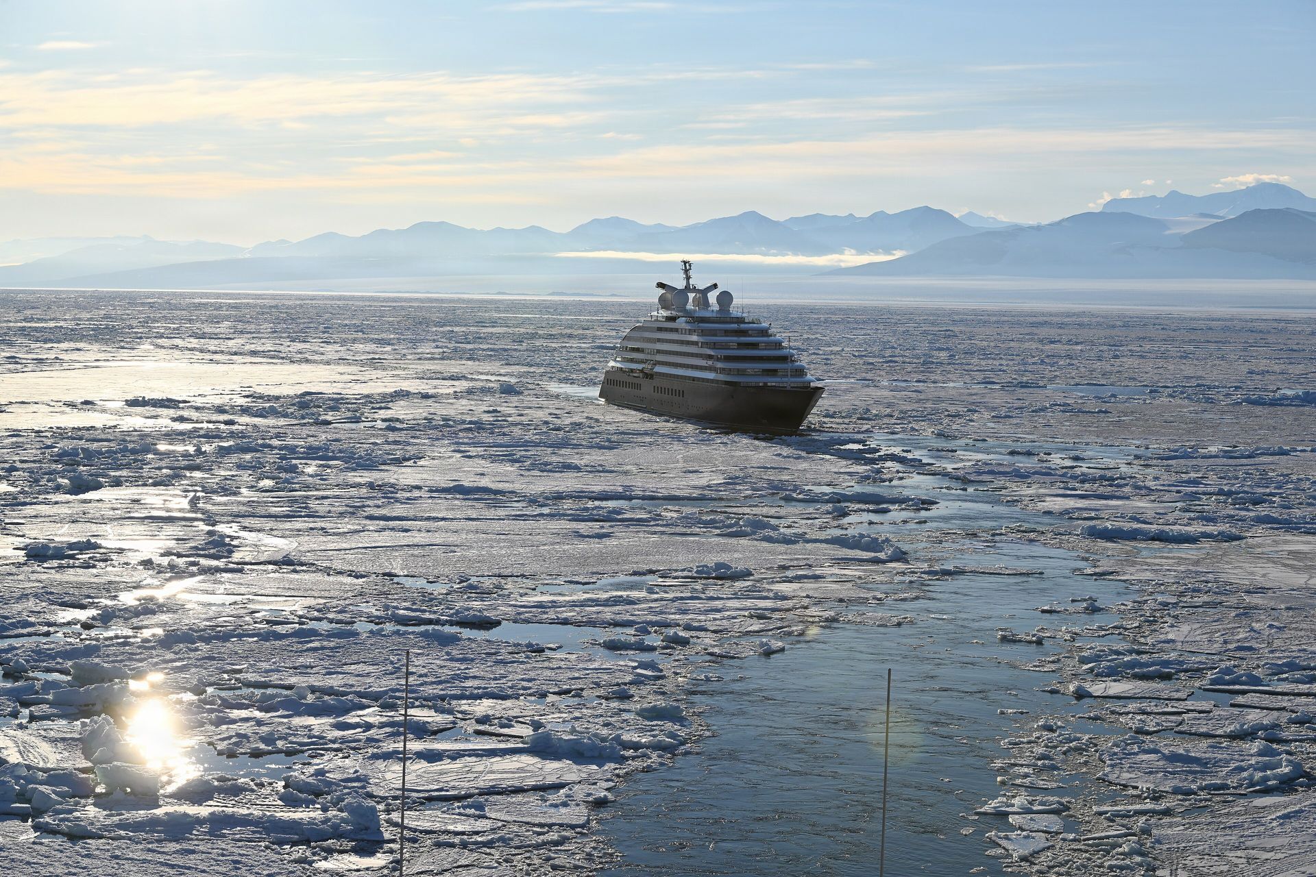 Scenic Eclipse II in Ross Sea pack ice below snow-covered mountains, seen from the icebreaker Polar Star, January 17, 2026