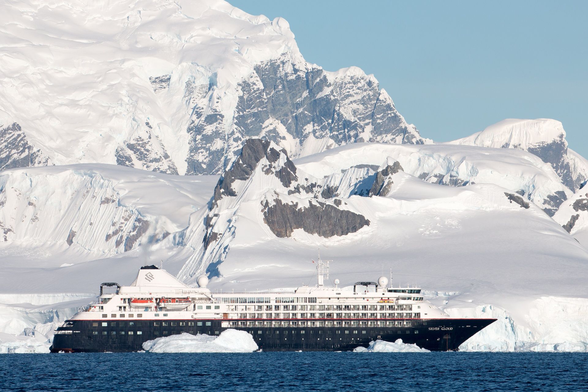 Silversea's expedition ship Silver Cloud below snow-covered mountains in Wilhelmina Bay, Antarctica