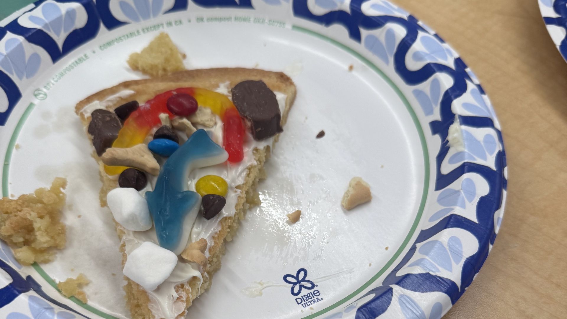 A slice of cookie pizza decorated with a gummy shark at summer camp