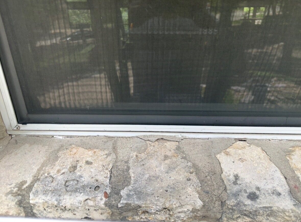 Before photo of staining and open joints under a Pflugerville window