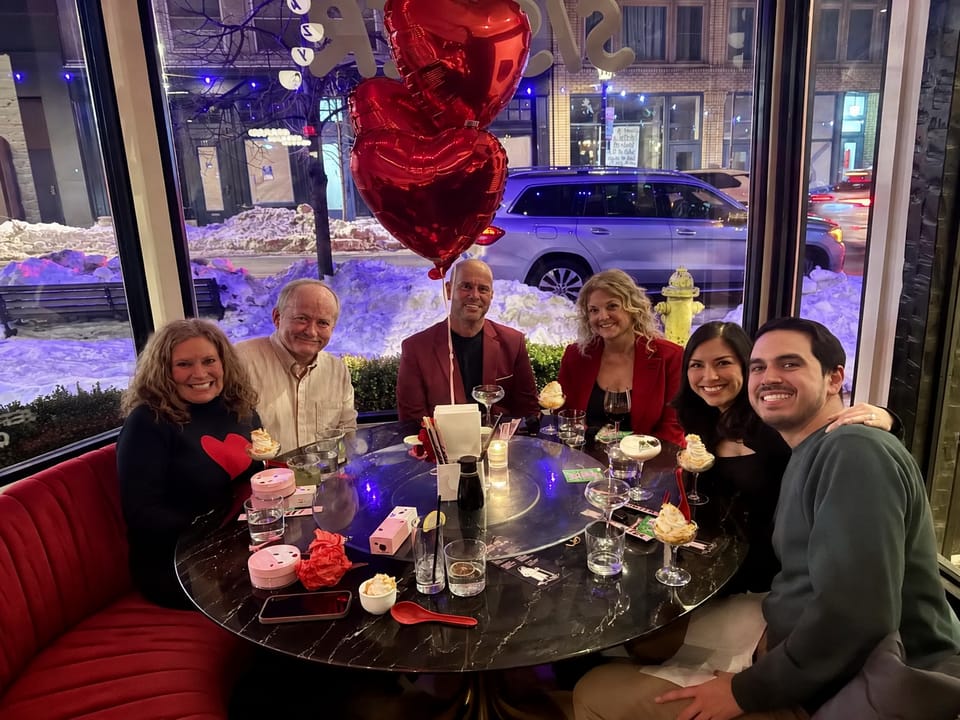 The team at a Valentine's dinner, red heart balloons overhead