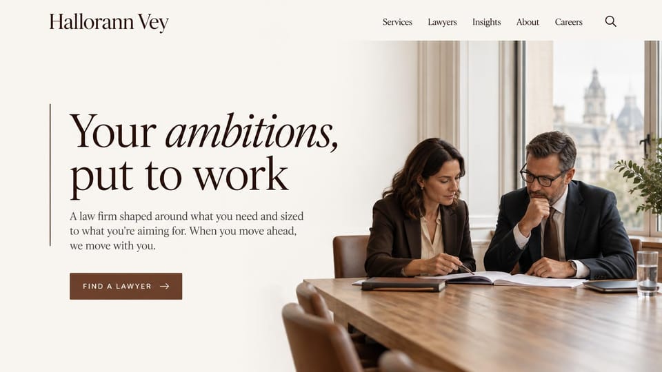 Law firm website design, business law, warm and editorial: ivory and wood tones, an italic serif headline beside two lawyers at a table