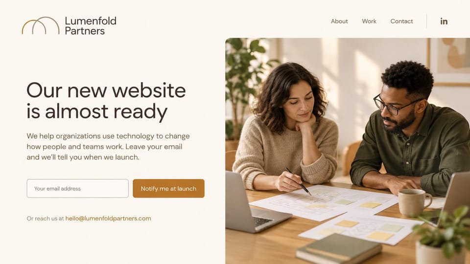 Coming soon website design, consulting firm's new website almost ready: cream page, a two-arch logo, a dark brown headline, an email field with a caramel button and a photo of two consultants planning at a table