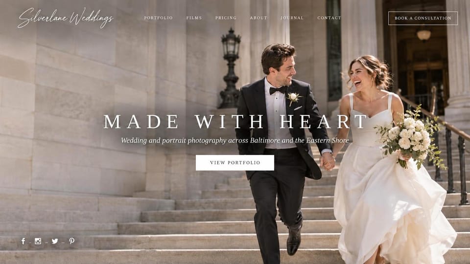 Wedding photographer website design, wedding and portrait photographer with a script logo: white script logo, a couple running down sunny stone steps of a columned building, spaced white capitals as the headline, a white button and small social icons