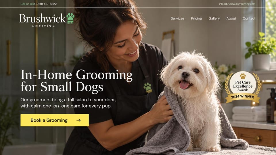 Pet business website design, in-home grooming for small dogs: warm dark photo of a groomer toweling a small white dog, a white serif headline, a yellow button and a gold award badge