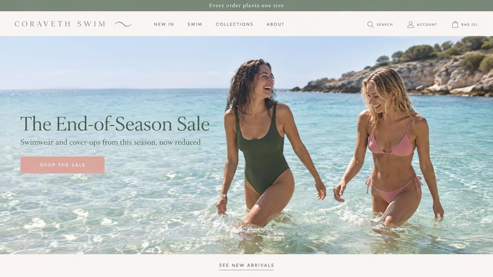 Fashion website design, swimwear sale with two friends wading in the sea: sage top bar, two laughing women wading in clear water in an olive one-piece and a pink bikini, a dark serif headline and a pink button