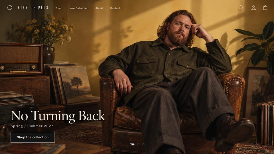 Fashion website design, menswear in a sunlit room with old records: warm amber room, a red-haired bearded man in an olive quilted overshirt and wool trousers in a worn leather armchair beside an old radio and records, a cream serif headline and an outlined button
