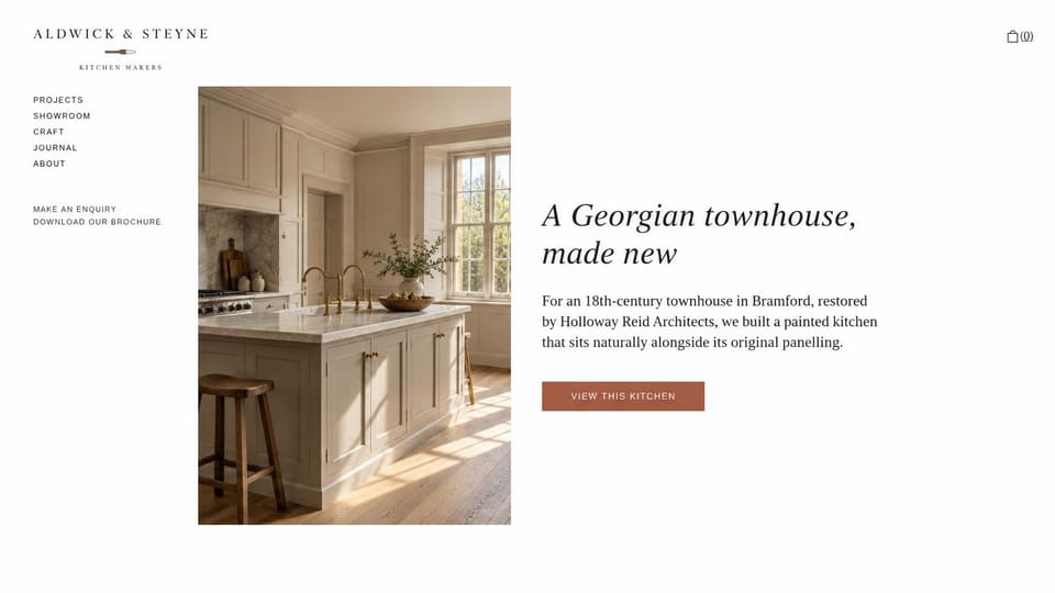 Carpentry website design, kitchen maker with one featured project: white page with a left menu, a tall photo of a painted kitchen island in a period room, an italic serif headline and a terracotta button