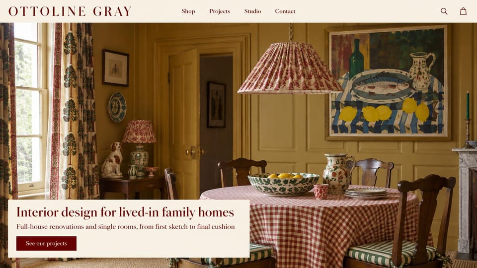 Interior design website design, traditional family homes in color and pattern: cream header and panel, a burgundy serif headline over a yellow dining room with gingham and printed curtains