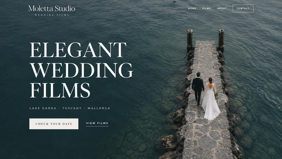 Wedding photographer website design, destination wedding films over deep lake water: full-bleed aerial photo of deep teal water and a stone pier with a couple walking, huge white serif capitals, spaced gray place names, a white date button and a films link