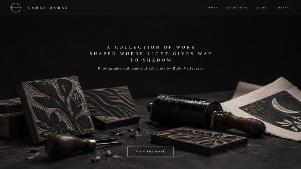 Artist website design, printmaking in low light: black page, carved printing blocks, a roller and prints in moody light under spaced ivory text