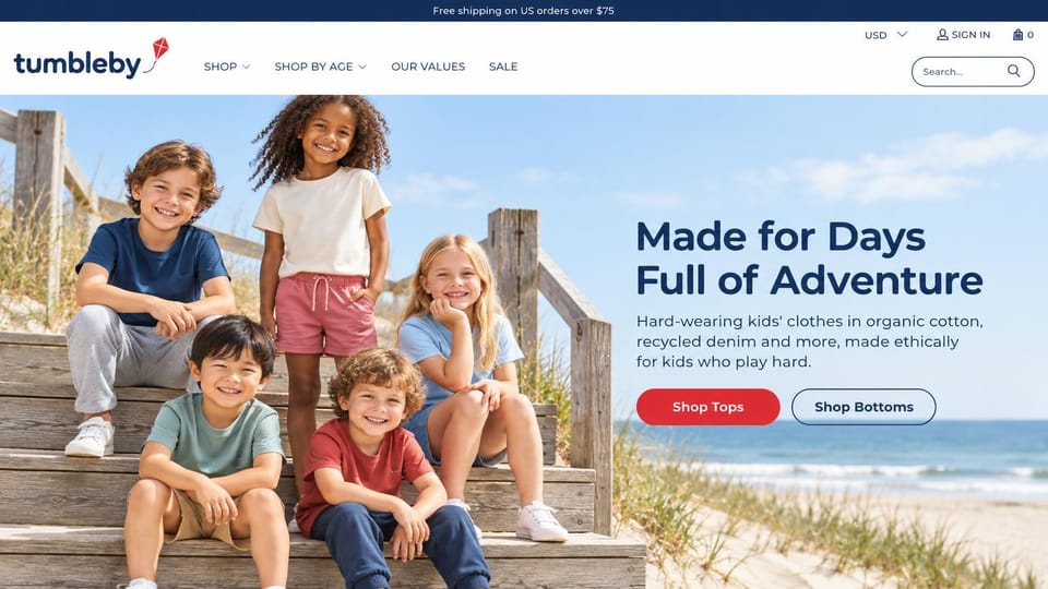 Fashion website design, kids' clothing with shop by age in the menu: navy top bar, five smiling kids in plain tees on beach boardwalk stairs, a bold navy headline, a red button and an outlined button