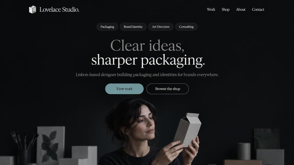 Portfolio website design, packaging designer in a dark studio: dark charcoal page, service tags and a centered white serif headline above a woman studying a paper carton