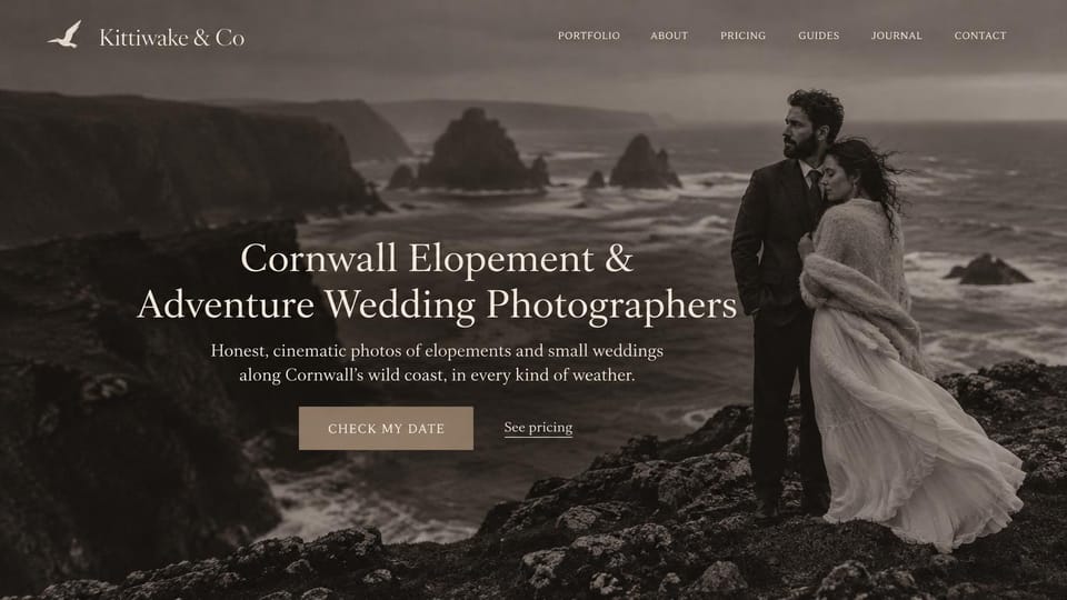 Wedding photographer website design, coastal elopement photographers in sepia: dark sepia photo of a couple wrapped in a shawl on rocky sea cliffs, a centered cream serif headline, a tan button and a pricing link