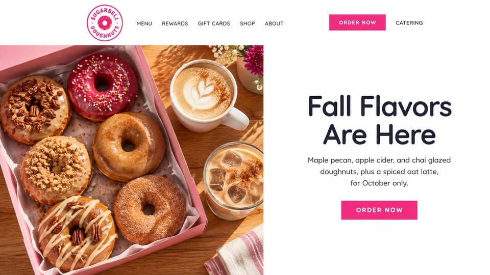 Cafe website design, doughnut shop with a seasonal box: white page, a pink doughnut box and iced coffee beside a navy headline and pink order button