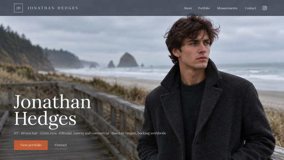 Model portfolio website design, male model with a stormy coast backdrop: slate gray header, a dark-haired man in a charcoal coat on a misty beach boardwalk, a large white serif name and a rust button