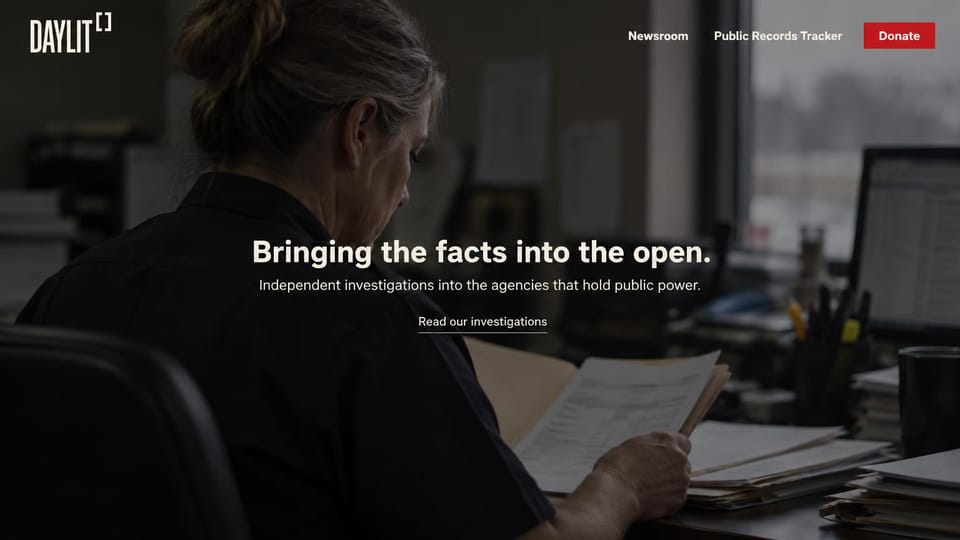 News and magazine website design, government watchdog with one centered line: dark photo of a reporter reading documents at an office desk, a centered white sans headline, an underlined link and a red donate button