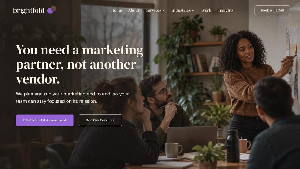 Agency website design, marketing partner in a warm work session: warm photo of a team planning at a wall, a cream serif headline, a purple button and an outlined one