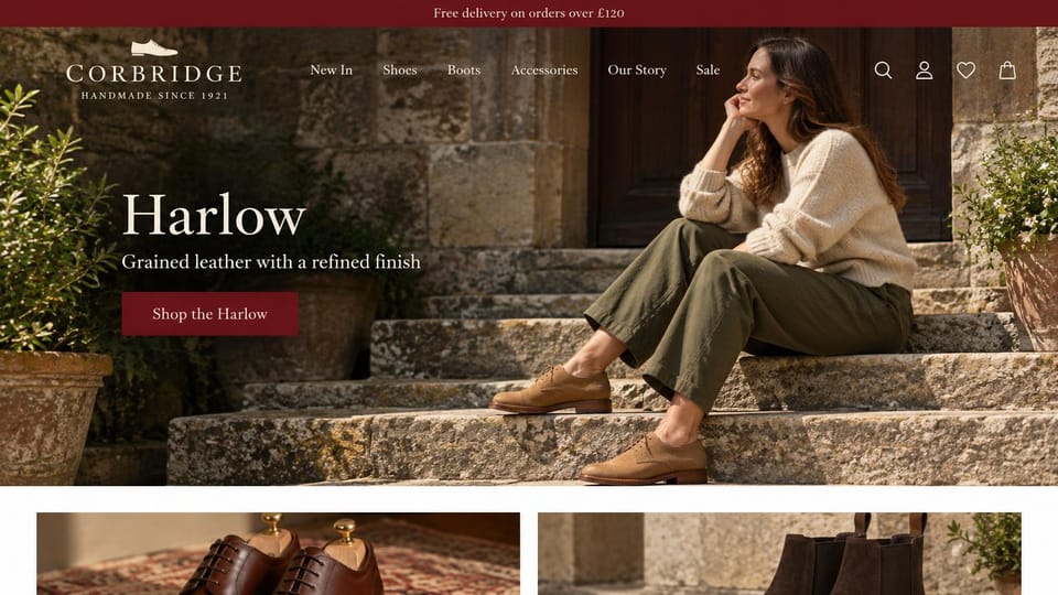 Fashion website design, handmade leather shoes with a shoe strip below: dark red top bar, a woman in a cream sweater and olive trousers on mossy stone steps in tan suede shoes, a white serif headline, a dark red button and shoe photos below