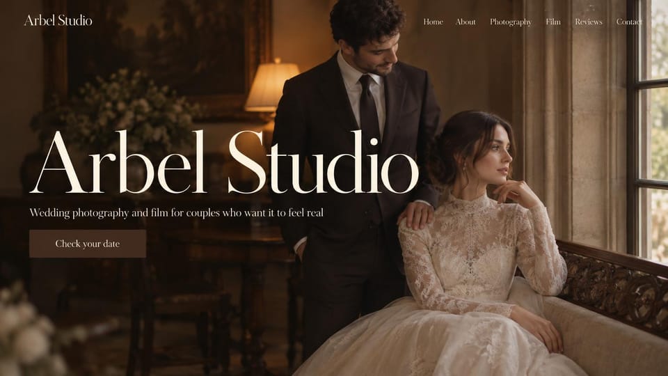 Wedding photographer website design, photo and film studio with an oversized name over a lace gown: warm dark interior by a window, a groom standing behind a seated bride in a high-neck lace gown, a huge cream serif name, a short line and a brown date button
