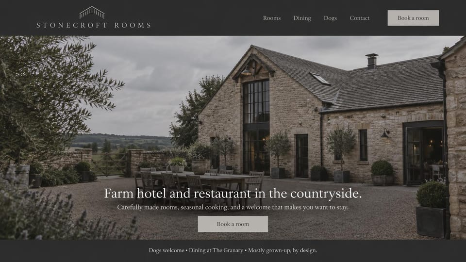 Hotel website design, farm hotel and restaurant, dogs welcome: a stone farmhouse and courtyard under a gray sky, a centered white serif headline and a gray button