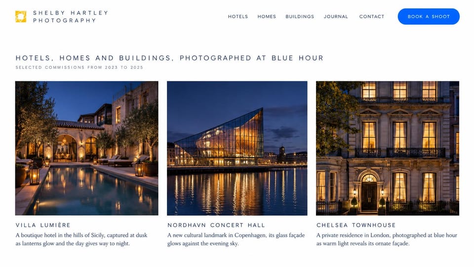 Photography website design, architecture and homes at blue hour: white page, a spaced navy headline and a blue book a shoot button above three lit buildings at dusk