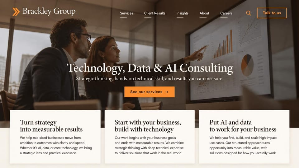 Consulting website design, technology and data consulting in warm serif: warm brown-toned photo of two consultants pointing at charts, centered cream serif headline, orange button, three cream cards