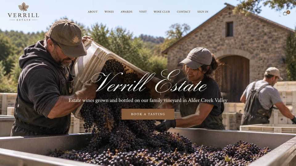Winery and brewery website design, harvest day with a script wordmark: photo of two workers tipping dark grapes into a bin by a stone barn, a large white script name across the middle and a small gold button