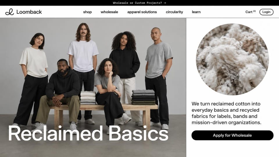 Fashion website design, reclaimed basics with a wholesale button: gray studio, six people in plain tees and hoodies around a bench of folded stacks, a huge white headline, a round close-up of cotton fiber on white and a black pill button