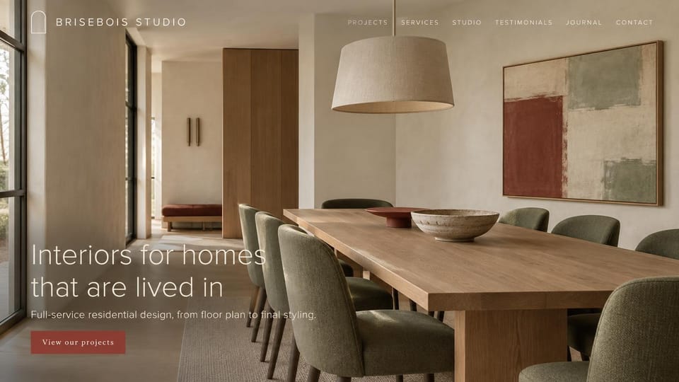 Interior design website design, residential studio with a large thin headline: full-screen dining room in oak and plaster with sage green chairs and a rust and sage painting, spaced white capitals, a large thin white headline and a rust button