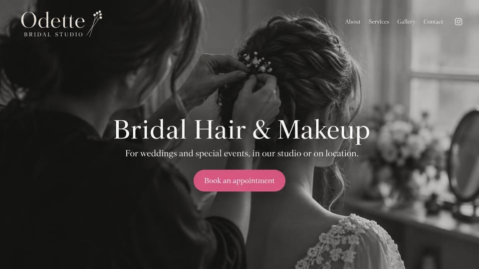 Makeup artist website design, bridal hair and makeup in a soft monochrome photo: full-width black and white photo of a stylist pinning flowers into a bride's hair, a centered white serif headline, a pink button