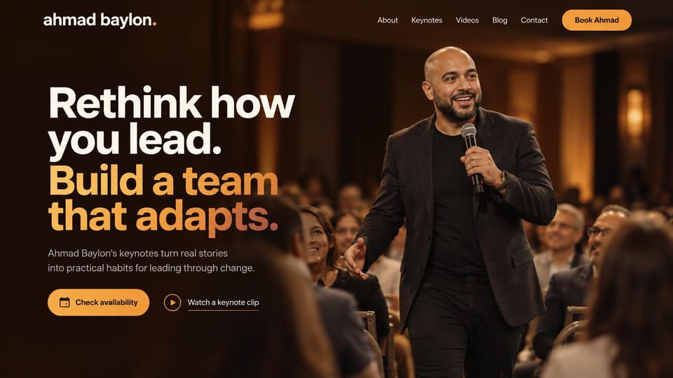 Speaker website design, leadership keynote speaker on a ballroom stage: warm-lit ballroom with a speaker holding a microphone among seated guests, bold white and orange sans headline, orange pill button
