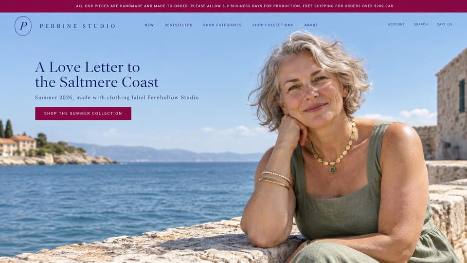 Jewelry website design, made-to-order jewelry with a sunny seaside portrait: burgundy top bar, sky blue photo of a gray-haired woman on a stone harbor wall wearing a gold necklace with a green stone, spaced navy wordmark, navy serif headline, burgundy shop button