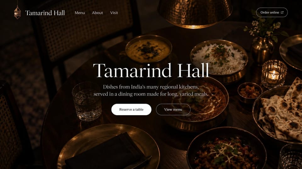 Restaurant website design, regional Indian, dark and intimate: dark overhead photo of Indian dishes on a candlelit table, white serif name and two buttons