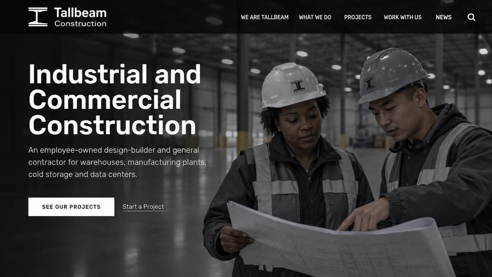 Construction website design, industrial design-build in black and white: black and white, two workers in hard hats reading plans in a warehouse beside a bold white headline