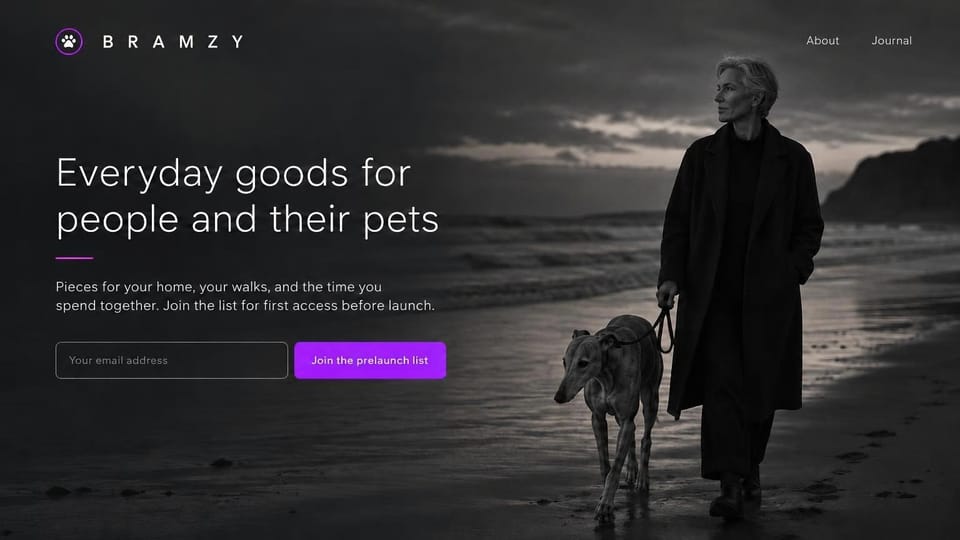 Coming soon website design, pet goods prelaunch list with a beach walk photo: full-bleed black and white photo of a woman in a long coat walking a greyhound on a dusky beach, light white headline at left with a short purple rule, an outlined email field and a bright purple button