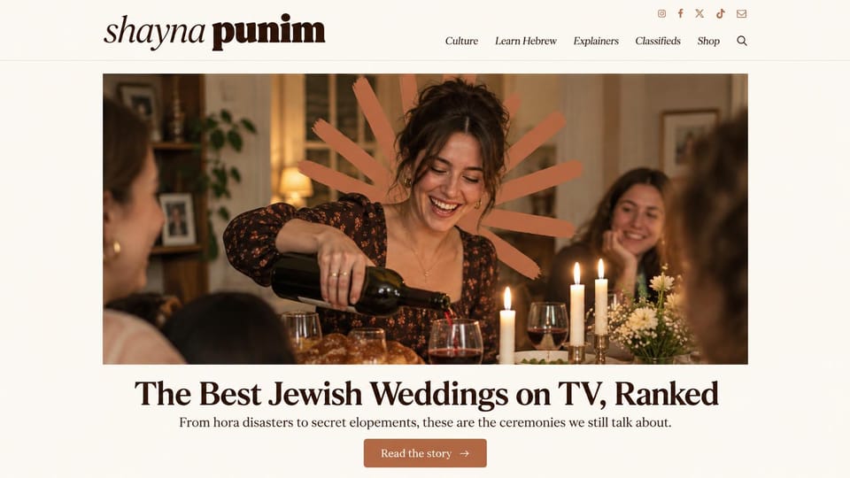 News and magazine website design, jewish culture magazine with a Shabbat table lead: cream page, brown italic and bold serif wordmark, an italic serif menu, small social icons, a woman laughing as she pours wine at a candlelit table with a terracotta brushstroke, a terracotta button