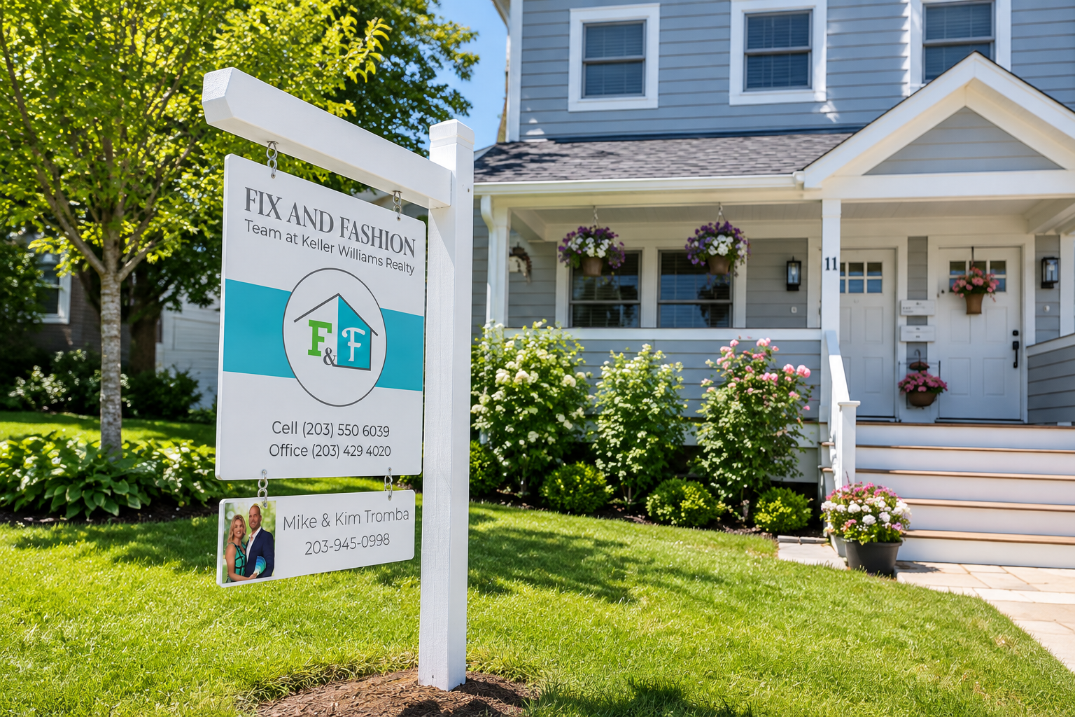The Fix and Fashion yard sign on a white post in front of a colonial house on a sunny day, with the Mike and Kim Tromba name rider below
