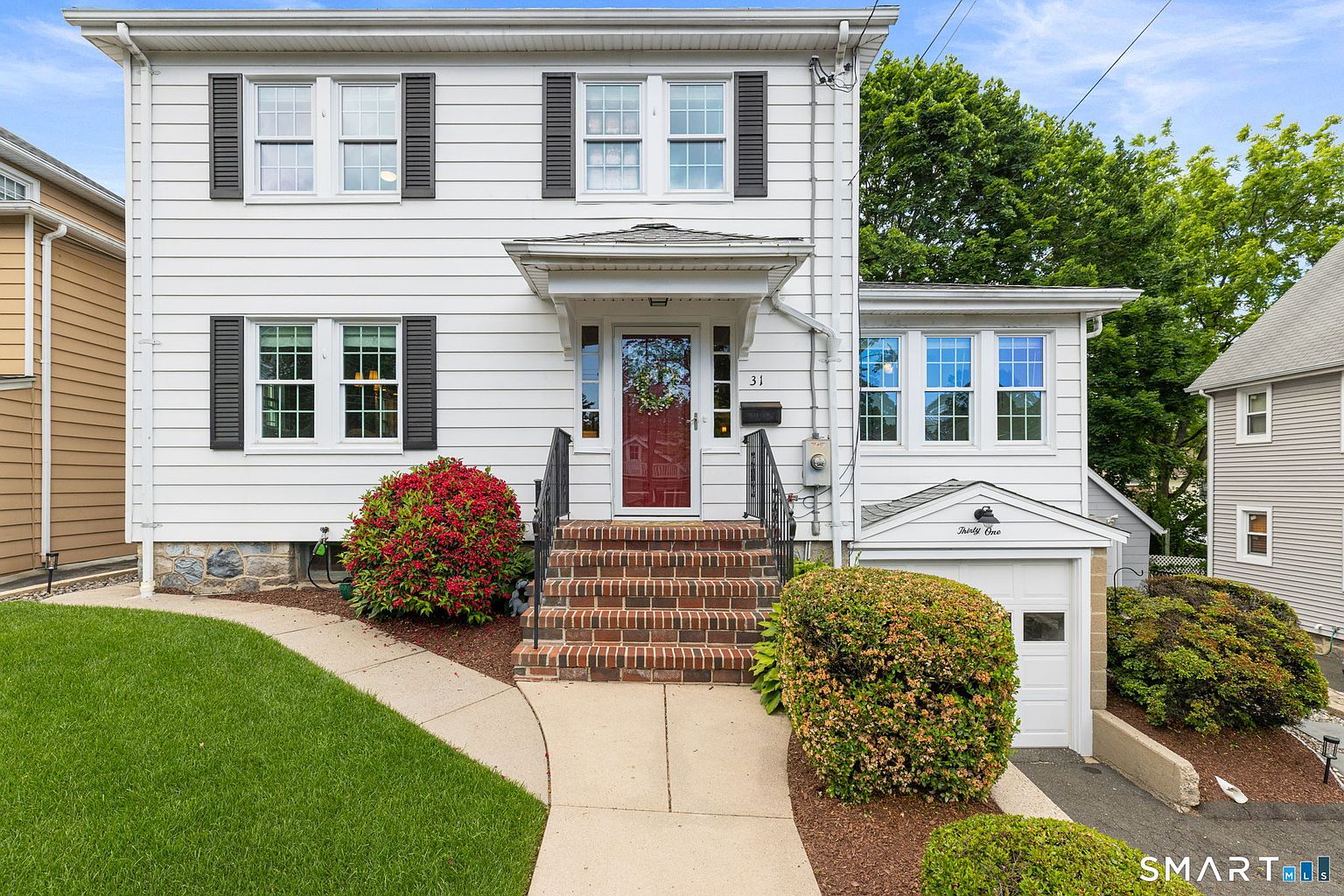 White colonial with a red front door at 31 Puritan Lane
