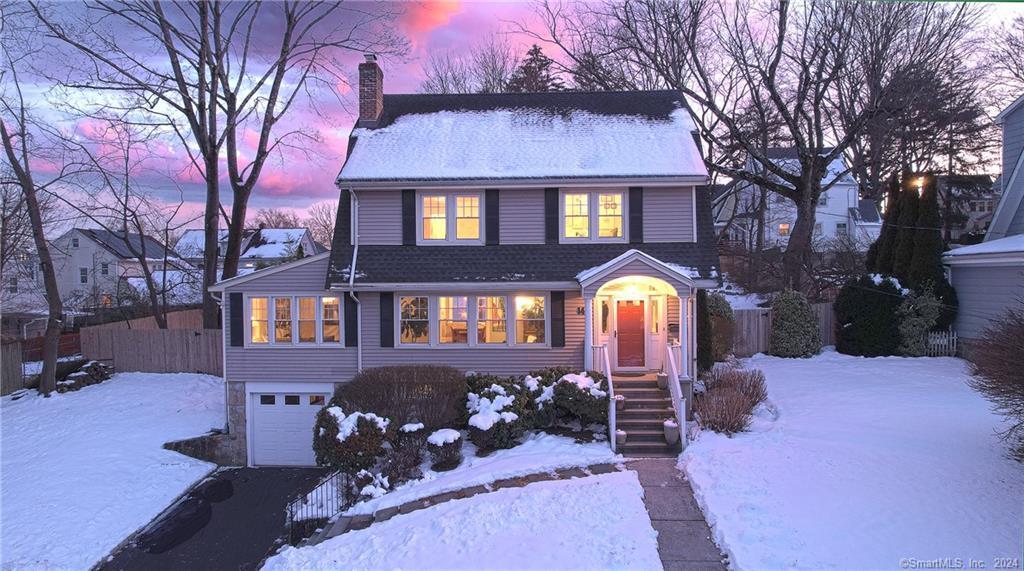 Colonial at dusk under fresh snow at 14 Howes Avenue